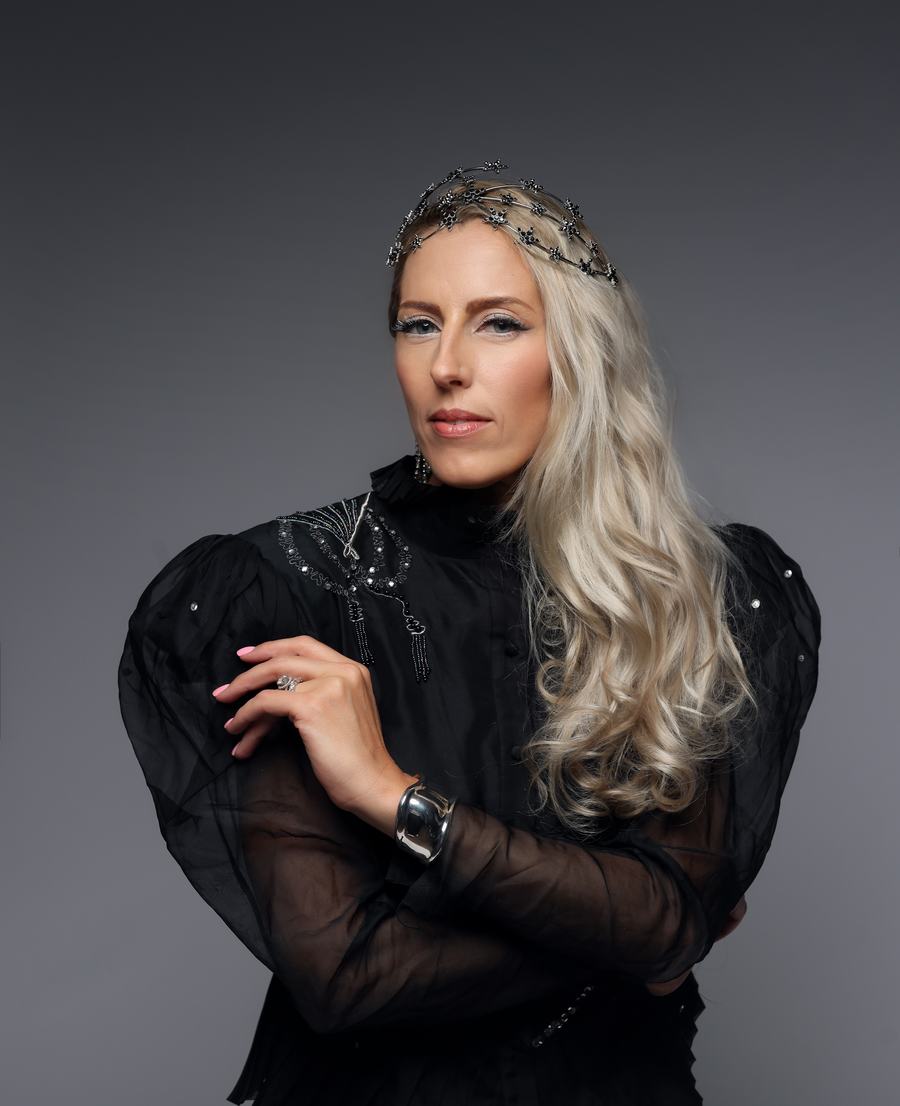 A jewelled headpiece and sheer black sleeves on grey