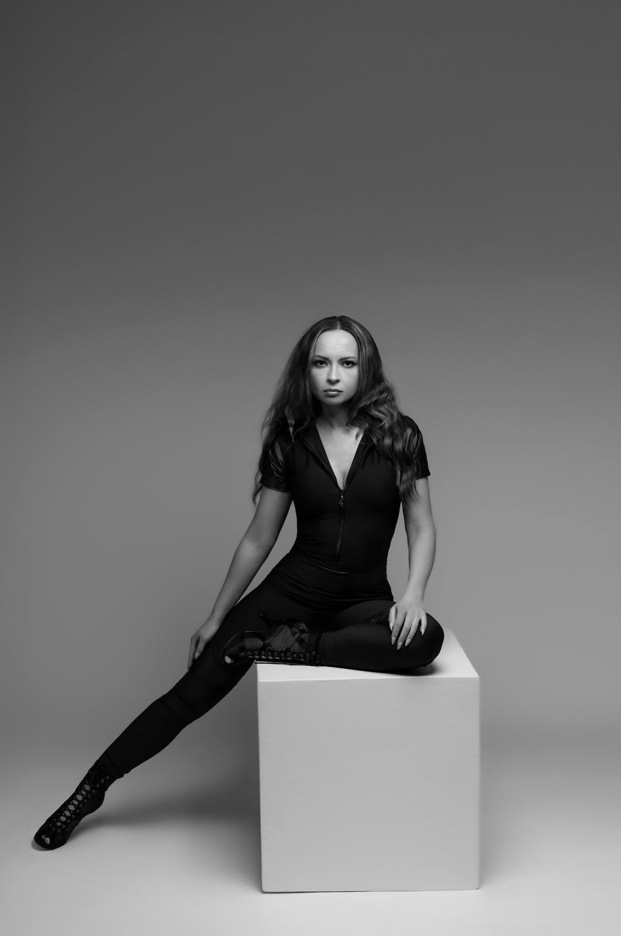 Black and white — seated on a white cube on grey seamless
