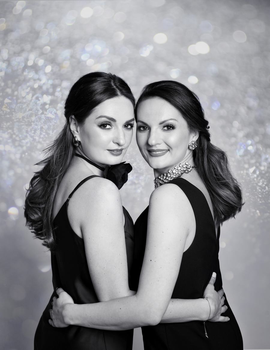 Black and white — two women cheek to cheek before glitter