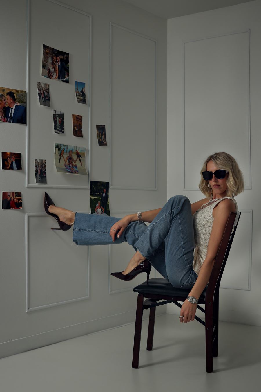 Liliya Ushin in sunglasses, feet up beside a wall of photographs