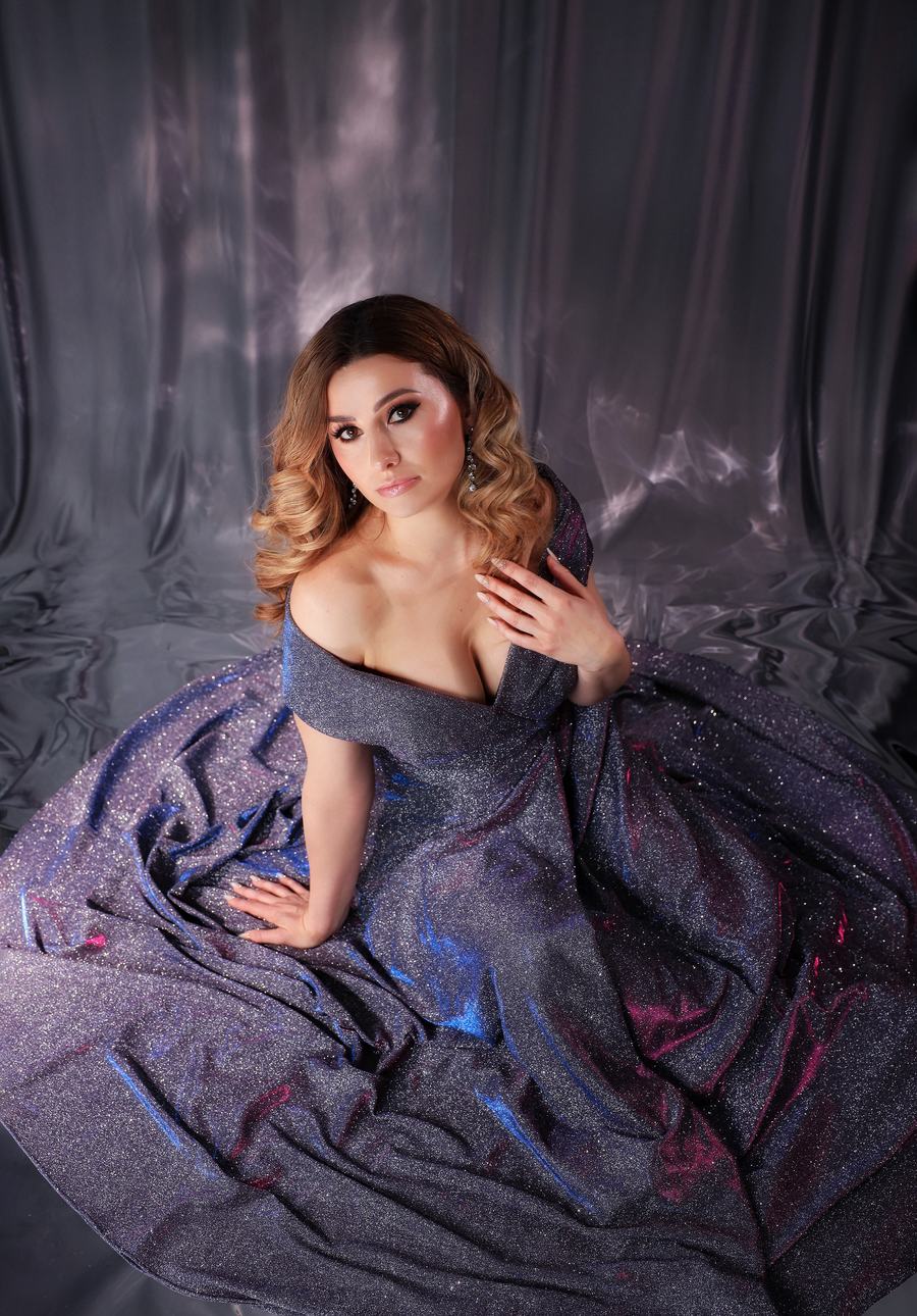A glittering gown spread across the floor of a silver set